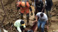 Orang-orang membawa jasad korban keluar dari reruntuhan setelah tanah longsor di Petropolis, Brasil, 16 Februari 2022. Banjir skala besar menghancurkan ratusan properti dan merenggut sebanyak 34 nyawa di daerah tersebut. (CARL DE SOUZA/AFP)