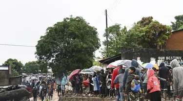 Orang-orang berdiri di tepi sungai yang mengalir deras di Blantyre, Malawi, Senin 13 Maret 2023. Topan Freddy yang tak henti-hentinya yang saat ini menghantam Afrika bagian selatan telah menewaskan lebih dari 50 orang di Malawi dan Mozambik sejak melanda benua itu untuk kedua kalinya pada hari Sabtu malam, (AP Photo/Thoko Chikondi)