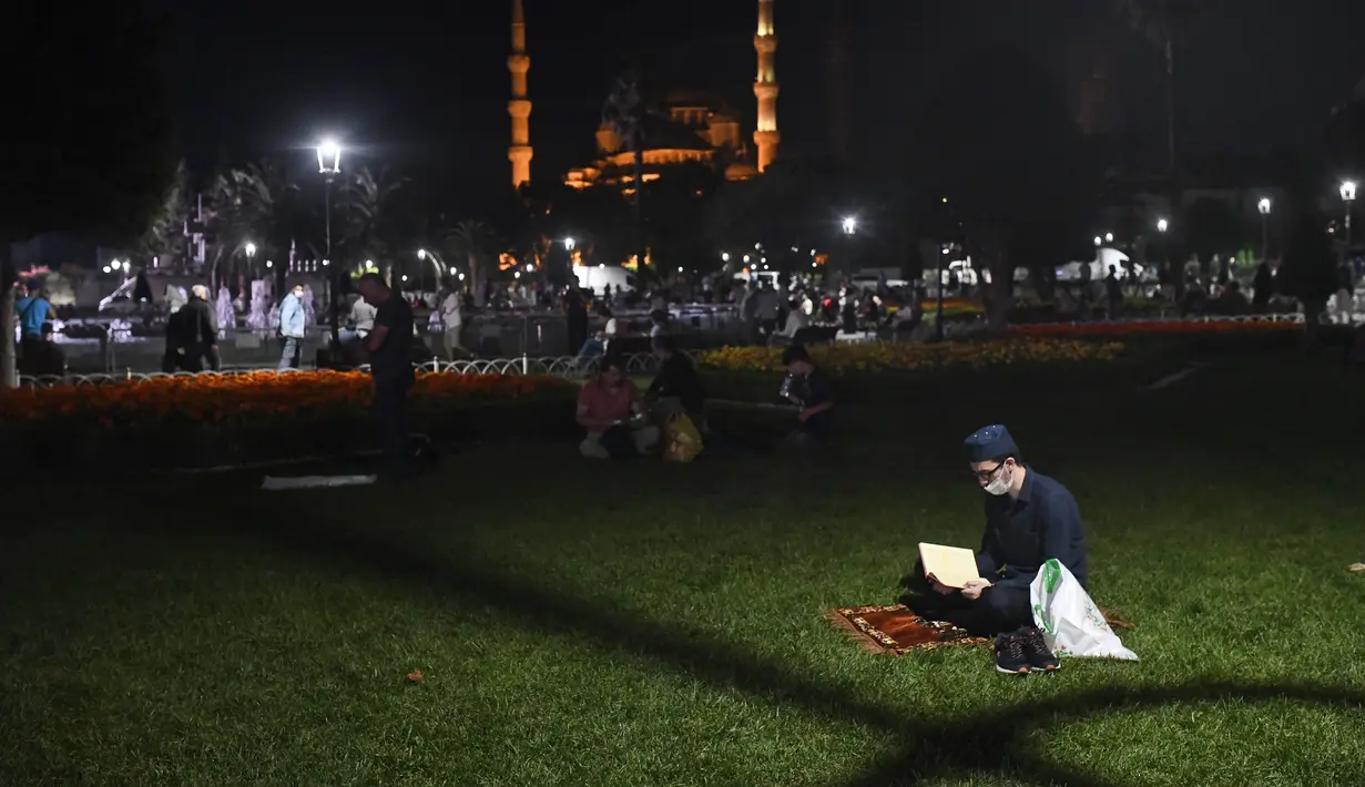 Seorang pemuda membaca dari Al-Quran sehari sebelum salat Jumat pertama di monumen tengara dalam 86 tahun setelah konversi kembali ke masjid di luar dirinya era-Bizantium Hagia Sophia, di distrik bersejarah Sultanahmet Istanbul, Kamis, (23/7/2020). (AP Photo/Omer Kuscu)