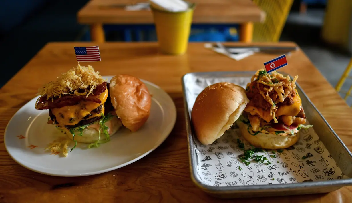 Burger "Durty Donald" dan "Kim Jong Yum" yang baru dibuat di sebuah restoran di Hanoi, Vietnam, 21 Februari 2019. Menu baru ini terinspirasi pertemuan puncak antara Presiden AS Donald Trump dan pemimpin Korut, Kim Jong-un. (Manan VATSYAYANA/AFP)