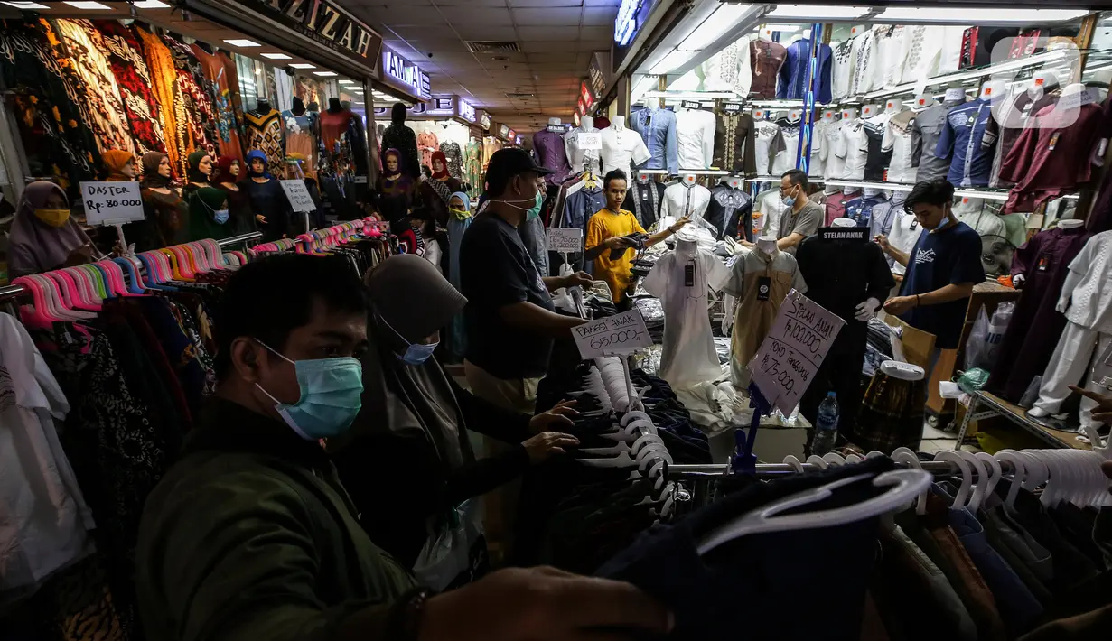 Warga memilih pakaian di Pasar Tanah Abang, Jakarta, Selasa (6/4/2021). Menjelang bulan Ramadan, Pasar Tanah Abang mulai dipadati pengunjung untuk berbelanja busana, namun menurut pedagang jumlah pengunjung bulan Ramadan kali ini tidak seramai sebelum pandemi Covid-19. (Liputan6.com/Johan Tallo)