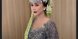 Ibu satu anak itu terlihat cantik maksimal kala mengenakan kebaya panjang berpayet nuansa keabuan yang dipadukan kain batik warna gelap. [@iniriezka]