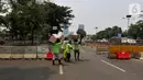 Petugas berjalan dekat road barrier beton yang dipasang di sekitar Gedung DPR RI, Jakarta, Kamis (17/10/2019). Direktorat Lalu Lintas Polda Metro Jaya kembali menutup sejumlah ruas jalan menuju kawasan Gedung DPR RI jelang pelantikan Presiden dan Wakil Presiden terpilih. (Liputan6.com/JohanTallo)