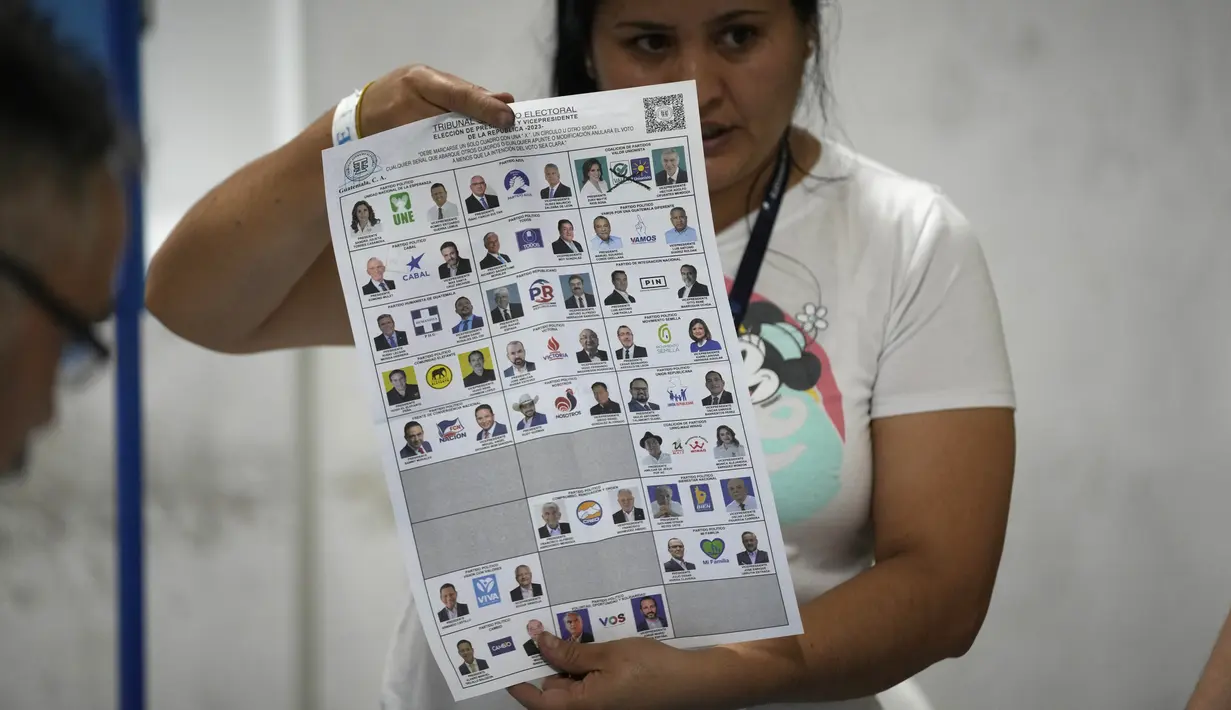 Seorang petugas pemilu menunjukkan surat suara saat penghitungan suara dimulai setelah pemungutan suara ditutup selama pemilihan umum di Guatemala City, Minggu, 25 Juni 2023. (AP Photo/Moises Castillo)