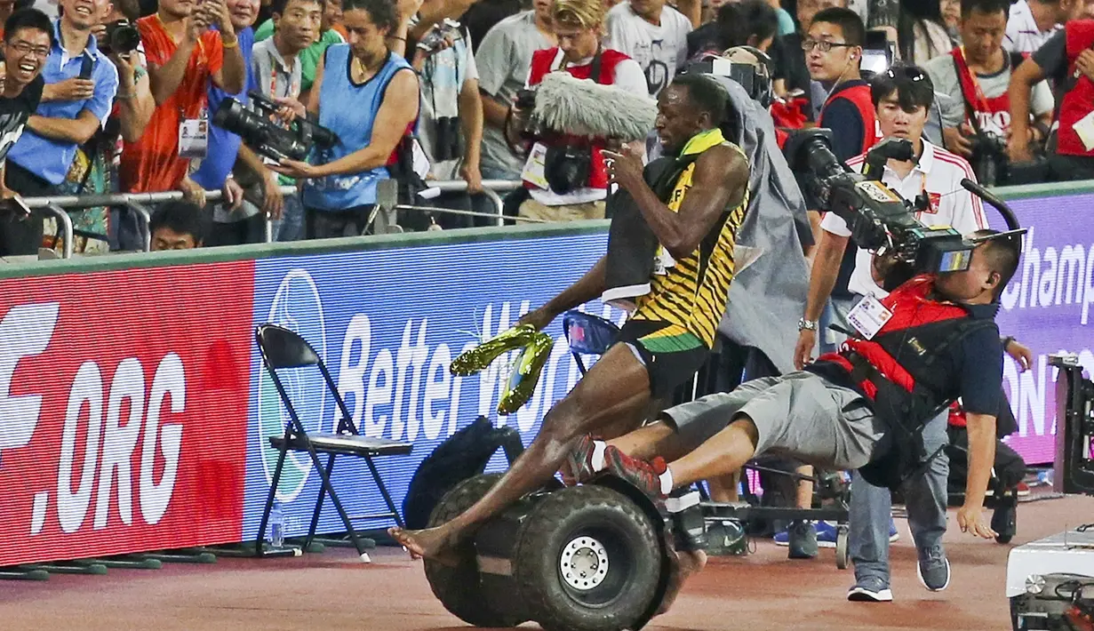 Usian Bolt terjatuh setelah ditabrak juru kamera yang menggunakan Segway saat merayakan kemenangan di nomor lari 200m Kejuaraan Dunia Atletik 2015 di Stadion Nasional, Beijing, Tiongkok. (27/8/2015). (Reuters)