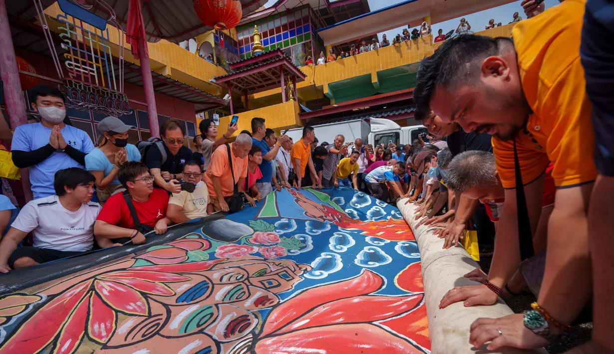 Di Malaysia, umat Budha membentangkan thangka raksasa saat perayaan waisak di Kuil Buddha Tibet di Ipoh. (AP Photo/Vincent Thian)