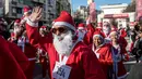 Seorang pria berpakaian Santa Claus melambaikan tangan saat mengikuti perlombaan lari tradisional Santa Claus Tahun Baru di Skopje, (24/12) (AFP Photo / Robert Atanasovki)