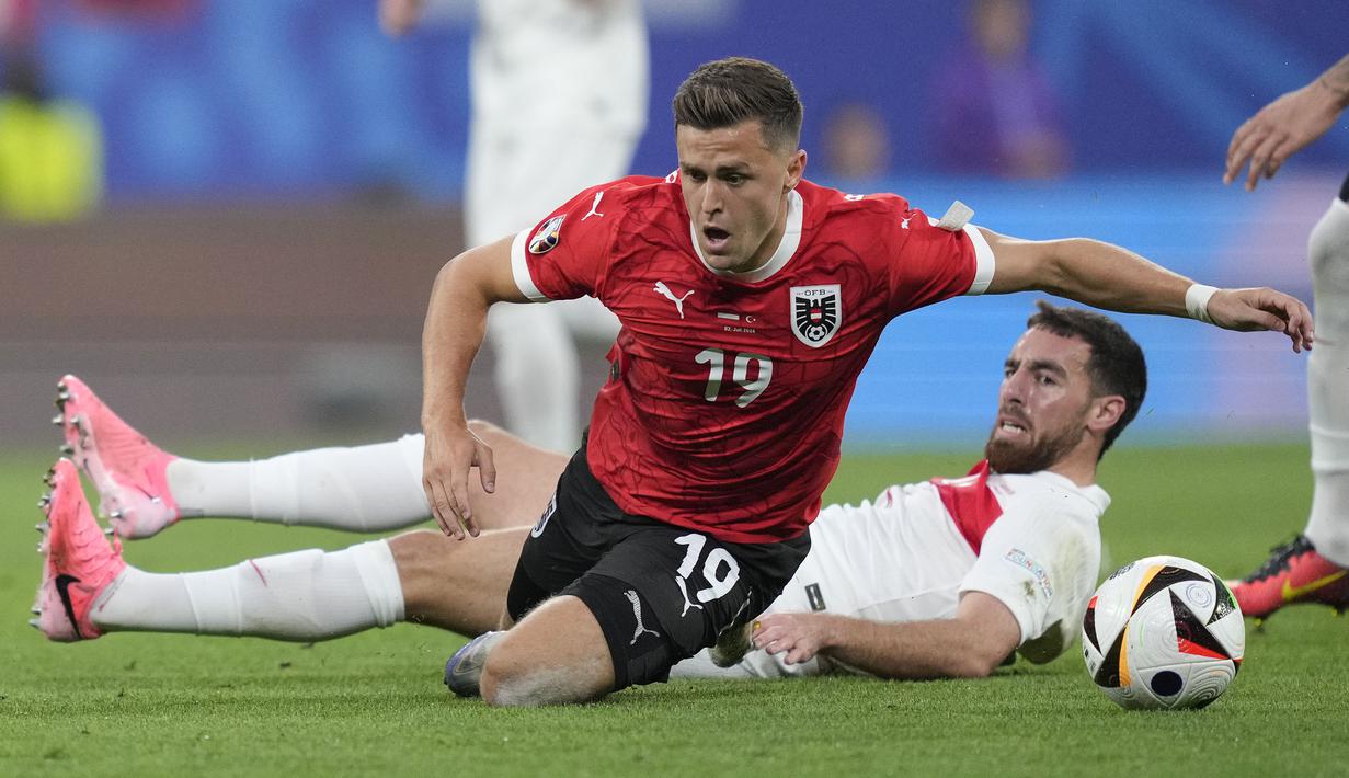 Gelandang Timnas Austria, Christoph Baumgartner (depan) terjatuh usai ditekel gelandang Timnas Turki, Orkun Kokcu pada laga babak 16 besar Euro 2024 di Red Bull Arena, Leipzig, Jerman, Rabu (3/7/2024). (AP Photo/Andreea Alexandru)