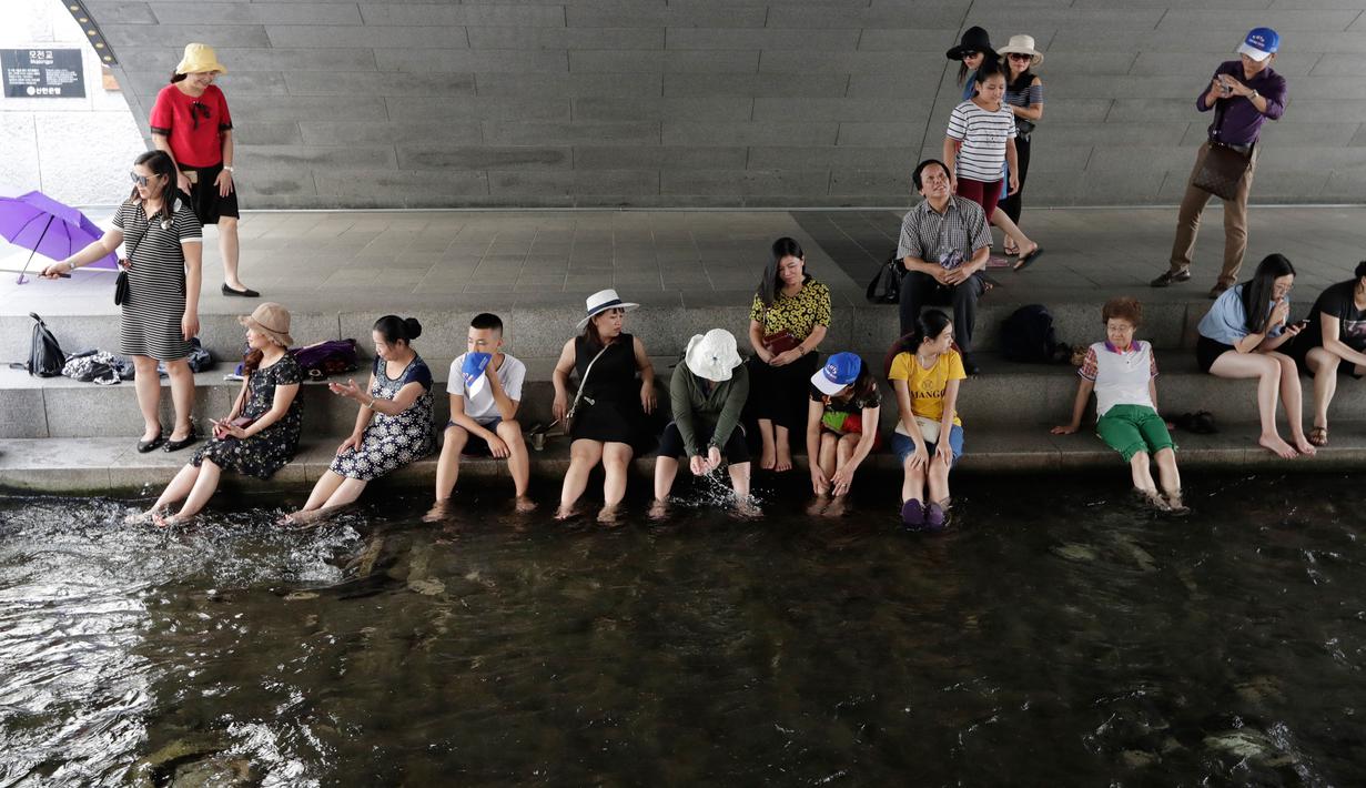 Warga bermain air saat siang hari di Sungai Cheonggye, Seoul, Korea Selatan, Senin (23/7). Suhu udara terik sekitar 33-37 derajat Celcius di seluruh negeri. (AP Photo/Lee Jin-man)