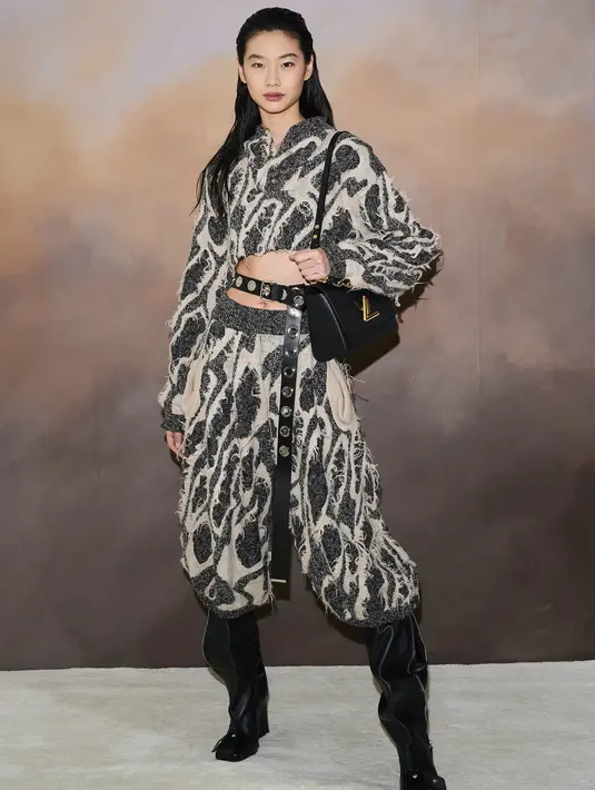 <p>Hoyeon tampil memesona di acara Louis Vuitton X British Vogue Dinner. Ia mengenakan set yang senada dengan high boots dan tas berwarna hitam. Foto: Document/Louis Vuitton.</p>