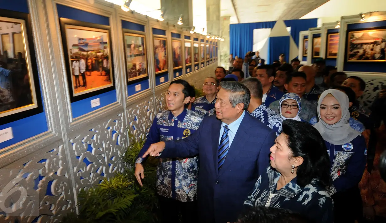 Ketua Umum Partai Demokrat, Susilo Bambang Yudhoyono (tengah) melihat pameran foto bertema kegiatan kader PD jelang puncak perayaan HUT Partai Demokrat ke-14 di Gedung Parlemen Senayan, Jakarta, Rabu (9/9/2015). (Liputan6.com/Helmi Fithriansyah)
