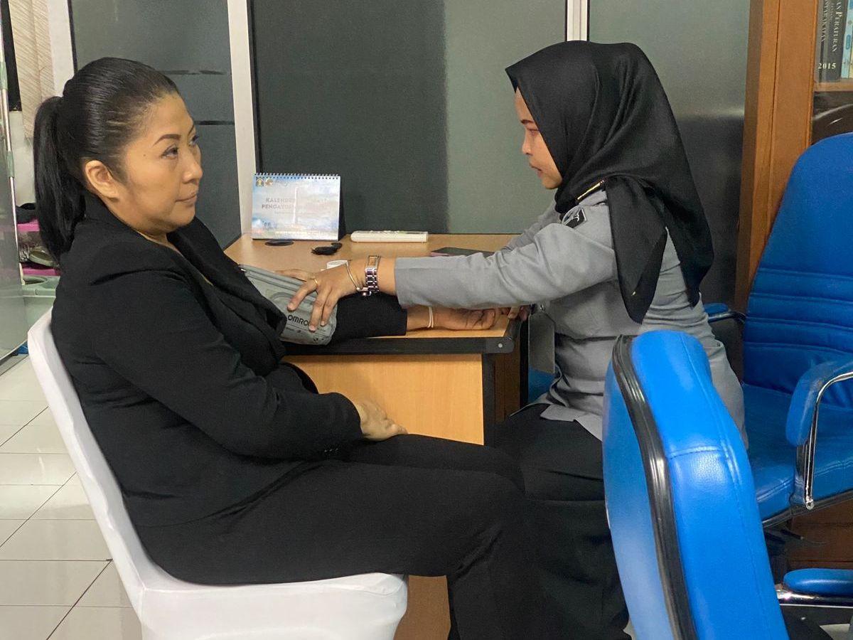 Putri terlihat memakai pakaian serta sepatu pantofel hitam.<br>