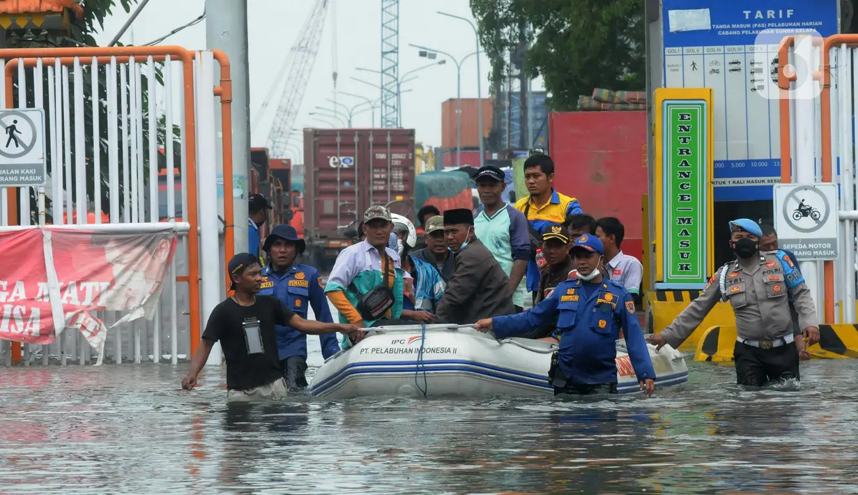 Petugas mengevakuasi warga dengan perahu karet saat banjir rob di kawasan Pelabuhan Sunda Kelapa, Jakarta, Selasa (7/12/2021). Banjir rob setinggi satu meter memutus Jalan Kerapu yang menghubungkan Ancol-Pluit. (merdeka.com/Arie Basuki)
