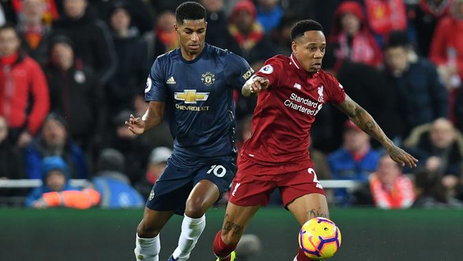 Bek Liverpool, Nathaniel Clyne, berebut bola dengan striker Manchester United, Marcus Rashford, pada laga Premier League di Stadion Anfield, Liverpool, Minggu (16/12). Liverpool menang 3-1 atas MU. (AFP/Paul Ellis)