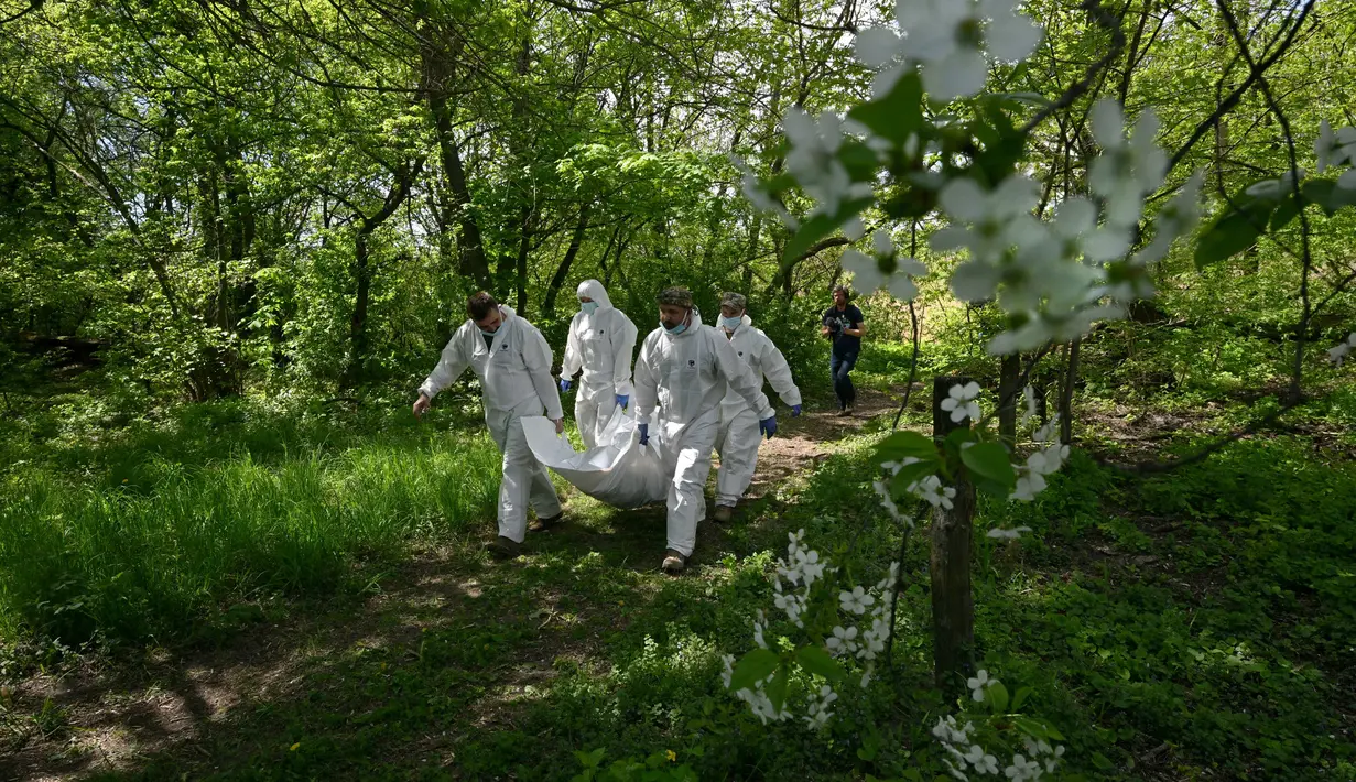 Pakar forensik Ukraina membawa jenazah seorang tentara Rusia yang digali di Desa Zavalivka, sebelah barat Kiev, Ukraina, 11 Mei 2022. Jenazah tersebut akan disimpan dalam gerbong berpendingin. (Sergei SUPINSKY/AFP)