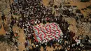 Warga Palestina berkumpul di sekitar jenazah warga Palestina yang tewas dalam serangan Israel selama perang dengan Hamas setelah ditemukan dari bawah reruntuhan bangunan, dalam prosesi pemakaman di Kota Gaza, Kamis (1/10/2026). Jenazah yang ditutupi bendera Palestina tersebut diiringi keluarga dan warga dalam suasana duka. (AP Photo/Yousef Al Zanoun)