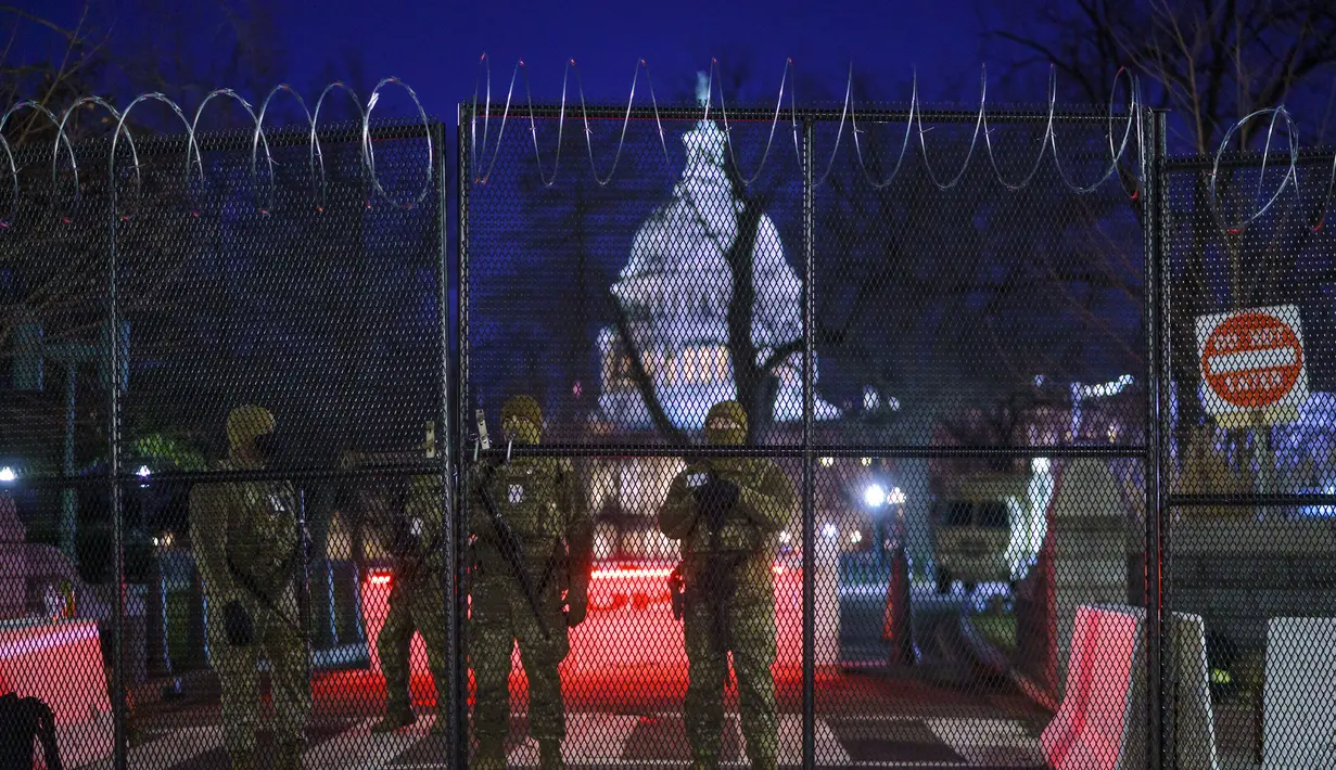 Pasukan Garda Nasional memperkuat zona keamanan di Capitol Hill, Washington, sebelum pelantikan Presiden terpilih Joe Biden, Selasa (19/1/2021). Pelantikan Joe Biden berlangsung di tengah ancaman kekerasan dari pendukung Donald Trump dan pandemi Covid-19. (AP Photo/J. Scott Applewhite)