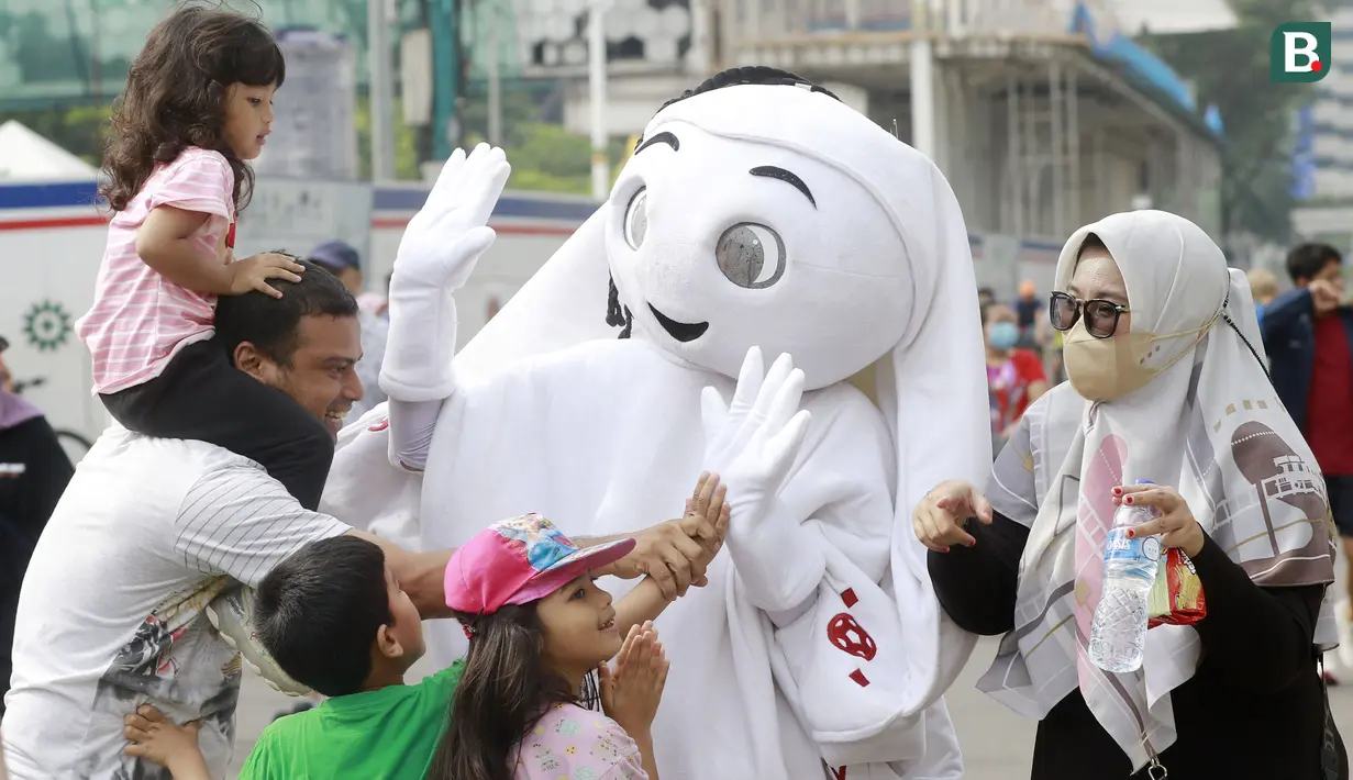 Sejumlah anak didampingi orang tuanya ttampak antusias menyapa maskot Piala Dunia 2022, La'eeb, saat Car Free Day (CFD) di kawasan Sudirman, Jakarta, Minggu (06/11/2022). (Bola.com/M iqbal Ichsan)