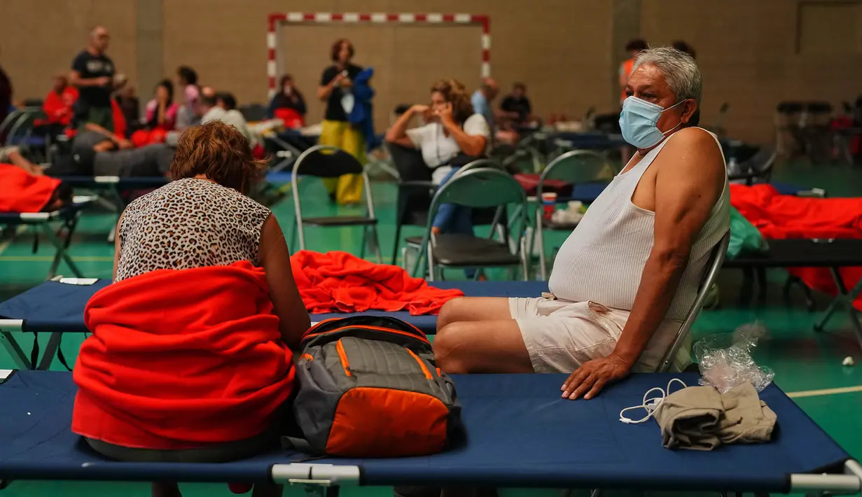 Warga bermalam di pusat olahraga setelah dievakuasi dari rumah mereka karena ancaman kebakaran hutan di Cebreros, provinsi Ávila, Spanyol, Jumat, 24 Juli 2026. (AP Photo/Manu Fernandez)