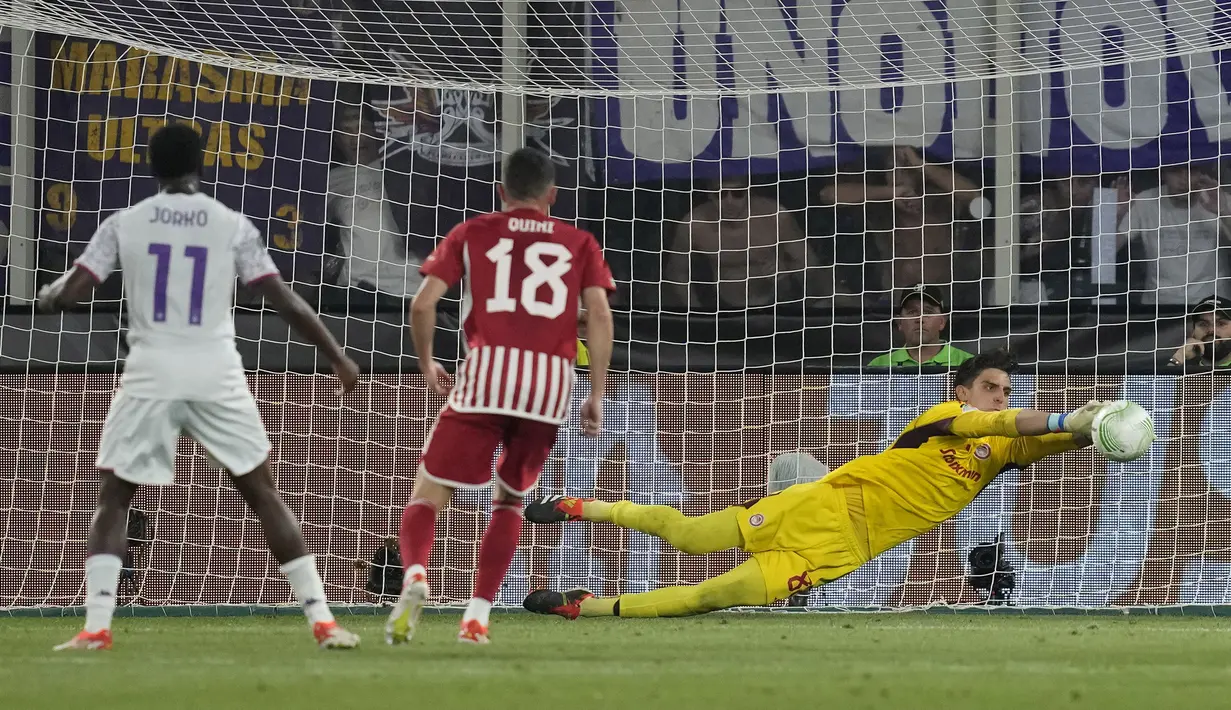 Kiper Olympiakos, Konstantinos Tzolakis melakukan penyelamatan saat menghadapi Fiorentina pada laga final Europa Conference League 2023/2024 di OPAP Arena, Athena, Yunani, Rabu (29/5/2024). (AP Photo/Thanassis Stavrakis)