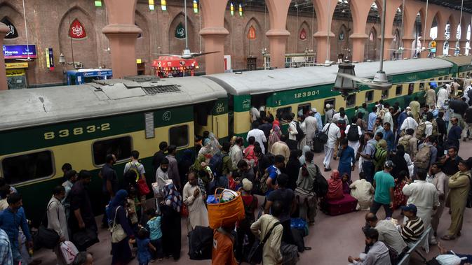 Para pelancong berebut memasuki pintu gerbong kereta saat mudik menuju kampung halaman untuk merayakan Idul Adha di stasiun Lahore, Pakistan, Sabtu (10/8/2019). Umat Islam di seluruh dunia merayakan Idul Adha yang identik dengan tradisi berkurban. (Photo by ARIF ALI / AFP)