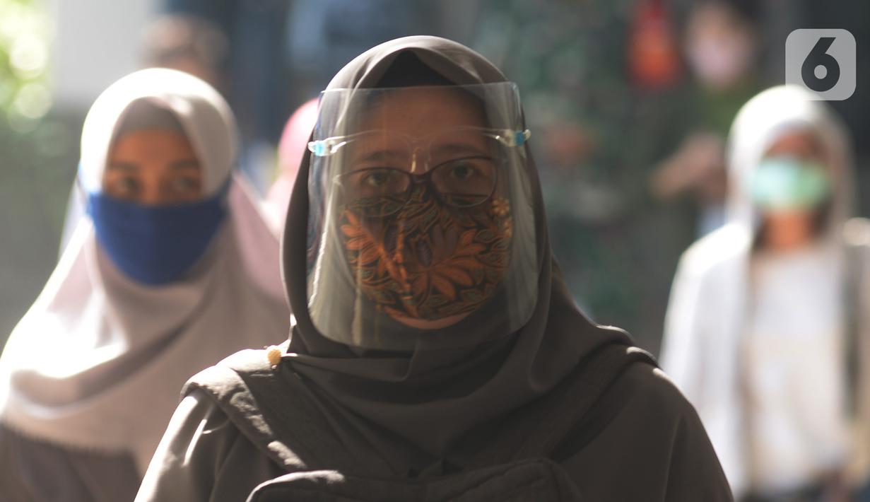 Seorang wanita yang mengenakan masker batik berjalan di kawasan Thamrin Sudirman, Jakarta, Jumat (2/10/2020). Pada Hari Batik Nasional yang berlangsung di tengah pandemi COVID-19, sebagian masyarakat terlihat mengenakan baju dan masker dengan motif batik. (merdeka.com/Imam Buhori)