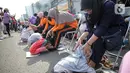 Sejumlah anak mencium kaki ibunya pada aksi cuci kaki ibu massal di Jakarta, Minggu (18/12/2022). Aksi yang diikuti sebanyak ratusann peserta itu bertujuan untuk meningkatkan rasa cinta kasih kepada ibu , khususnya dalam rangka memperingati Hari Ibu. (Liputan6.com/Faizal Fanani)