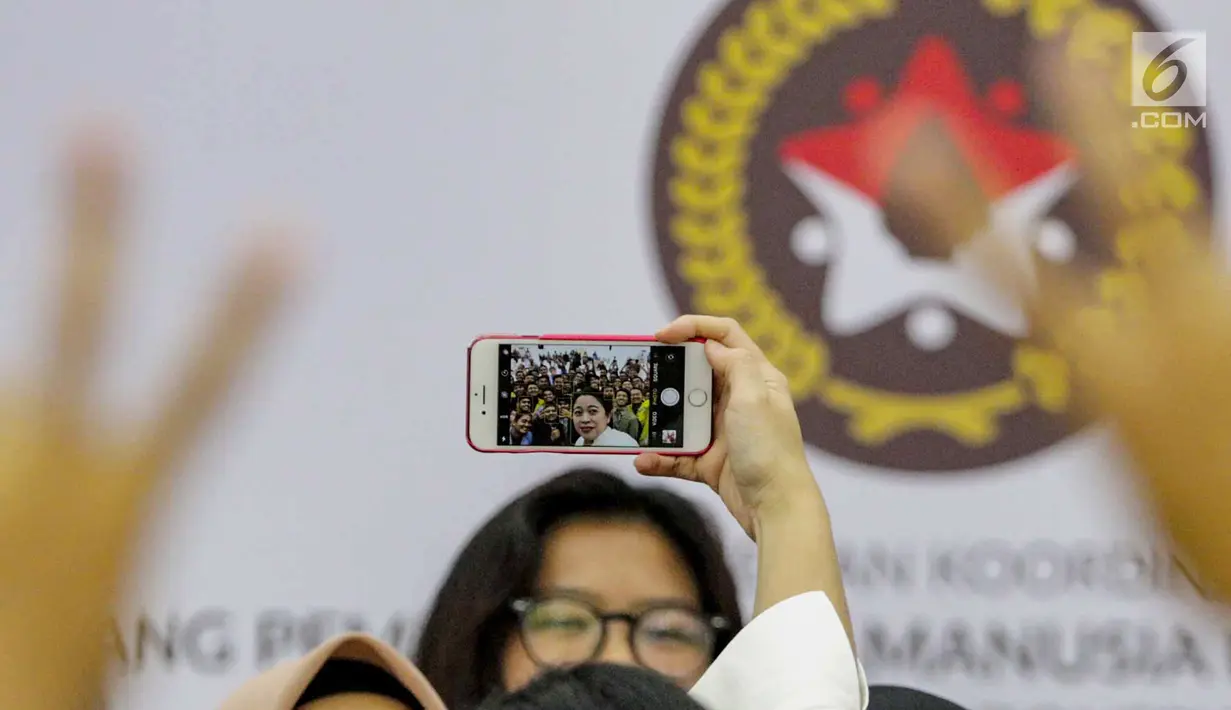 Sebuah handphone memperlihatkan gambar Menko PMK Puan Maharani sedang foto bersama perwakilan mahasiswa penerima beasiswa Teladan Tanoto Foundation di Kantor Kemenko PMK di Jakarta, Selasa (5/3). (Liputan6.com/Faizal Fanani)