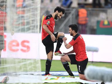 Gelandang Mesir Mahmoud 'Trezeguet' Hassan (kanan) berselebrasi dengan Mohamed Salah setelah mencetak gol pada menit ke-100 ke gawang Maroko pada pertandingan perempat final Piala Afrika (CAN) 2021 di Stade Ahmadou Ahidjo di Yaounde (30/1/2022). Mesir menang atas Maroko 2-1. (AFP/Charly Triballeau)