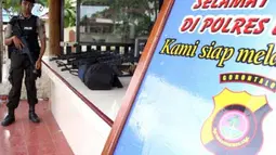 Seorang anggota Polisi lengkap dengan senjata laras panjang bersiaga di Mapolres Limboto, Gorontalo, Kamis (26/4). Polisi memperketat pengamanan pasca meninggalnya Prada Firman anggota Yonif 713 Kostrad, korban bentrokan antara Brimob Polda Gorontalo dengan sejumlah personel batalyon infanteri tersebut. (Antara)