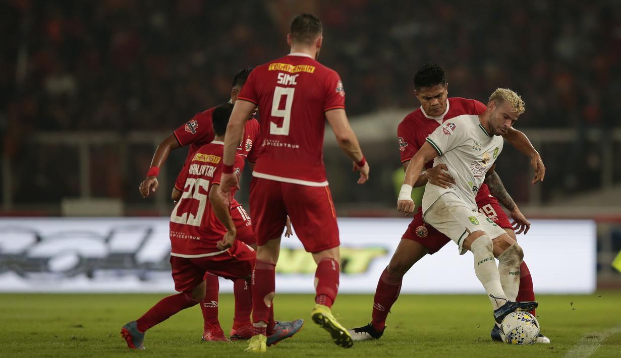 Striker Persebaya, Diogo Campos, berebut bola dengan pemain Persija Jakarta pada laga Shopee Liga 1 di SUGBK, Jakarta, Selasa (17/12). Persebaya menang 2-1 atas Persija. (Bola.com/Yoppy Renato)