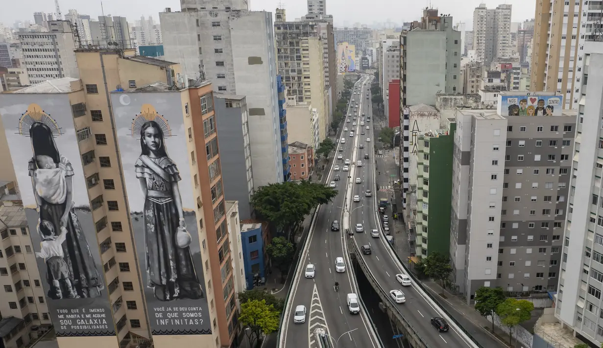 Mural raksasa karya seniman Hanna Lucatelli dipajang di dinding bangunan di Sao Paulo, Brasil, Rabu (29/9/2021). Para seniman mural papan atas dikerahkan membuat lukisan raksasa karya terbaik mereka untuk berpartisipasi dalam festival di kota tersebut selama seminggu. (AP Photo/Andre Penner)
