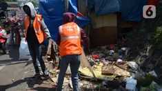 Warga pelanggar PSBB (Pembatasan Sosial Berskala Besar) membersihkan sampah setelah dijatuhi hukuman saat terjaring razia di Pasar Gembrong, Jakarta, Selasa (2/6/2020). Para pelanggar aturan PSBB tersebut dijatuhi sanksi membayar denda atau melakukan pelayanan sosial. (merdeka.com/Imam Buhori)