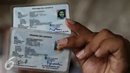 Warga menunjukkan kartu tanda penduduk (KTP) regularnya di Jakarta, Rabu (21/10). Kepala Disdukcapil DKI Jakarta, Edison Sianturi mengatakan, proses perekaman E-KTP di Jakarta dilaksanakan paling lambat 31 Desember 2015. (Liputan6.com/Immanuel Antonius)