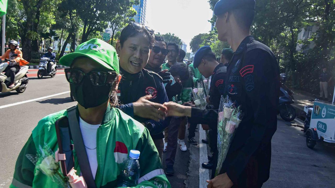 FOTO: Aksi Damai Ojol Tebar Mawar untuk Perdamaian