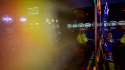 Sejumlah lansia bermain mesin slot di Dover Downs Casino, Delaware (5/6). Delaware adalah negara bagian pertama AS yang meluncurkan permainan taruhan legal. (Mark Makela/Getty Images North America/AFP)