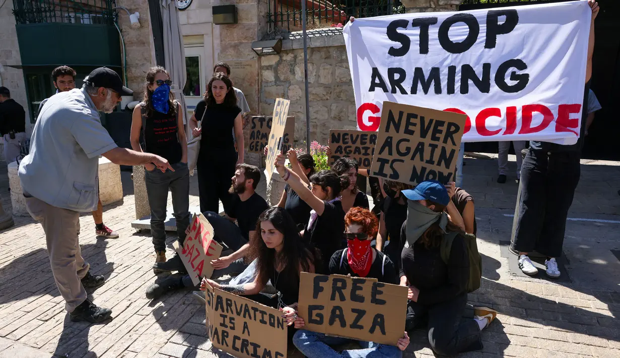 Seorang petugas keamanan di konsulat AS di Yerusalem memberi peringatan kepada para aktivis sayap kiri Israel yang berunjuk rasa memprotes perang yang sedang berlangsung di Gaza, di depan gedung konsulat, pada 24 Mei 2024. (AHMAD GHARABLI/AFP)