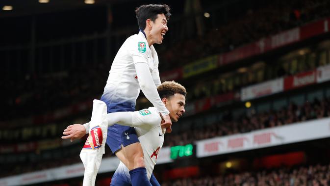Gelandang Tottenham Hotspur, Dele Alli berselebrasi dengan rekannya, Son Heung-min setelah mencetak gol ke gawang Arsenal pada perempat final Piala Liga Inggris di Stadion Emirates, Kamis (20/12). Tottenham menang 2-0 atas Arsenal. (AP/Frank Augstein)
