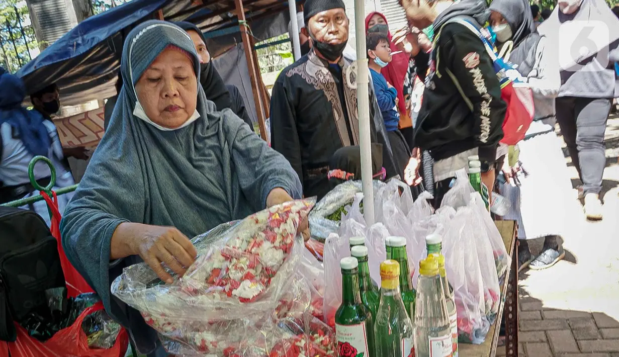 Penjual menata bunga tabur di TPU Karet Tengsin, Jakarta, Minggu (27/3/2022). Sebagian warga memanfaatkan waktu jelang Ramadan menjadi penjual bunga tabur musiman untuk memenuhi kebutuhan ziarah ke makam yang dijual Rp 5.000 - Rp 20.000 per kantong plastik. (Liputan6.com/Faizal Fanani)