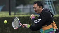 Menpora Imam Nahrawi berusaha memukul bola saat bermain dengan atlet tenis Indonesia di Hotel Sultan, Jakarta, Kamis (24/5/2018). Menpora datang memantau persiapan pelatnas tenis jelang Asian Games 2018. (Bola.com/Vitalis Yogi Trisna)