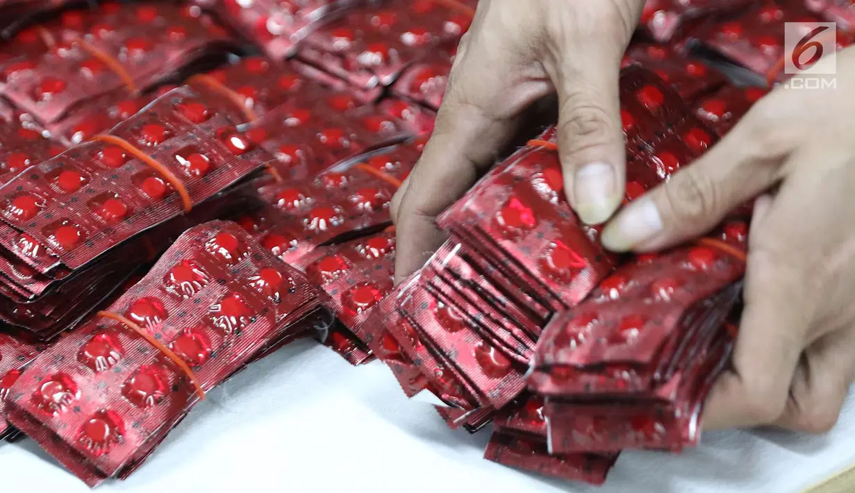 Petugas memperlihatkan barang bukti saat rilis penyelundupan kasus narkoba di Gedung Kantor Pos Pasar Baru, Jakarta, Senin (10/9). 30ribu butir happy five juga diselundupkan melalui barang kiriman pos. (Liputan6.com/Immanuel Antonius)