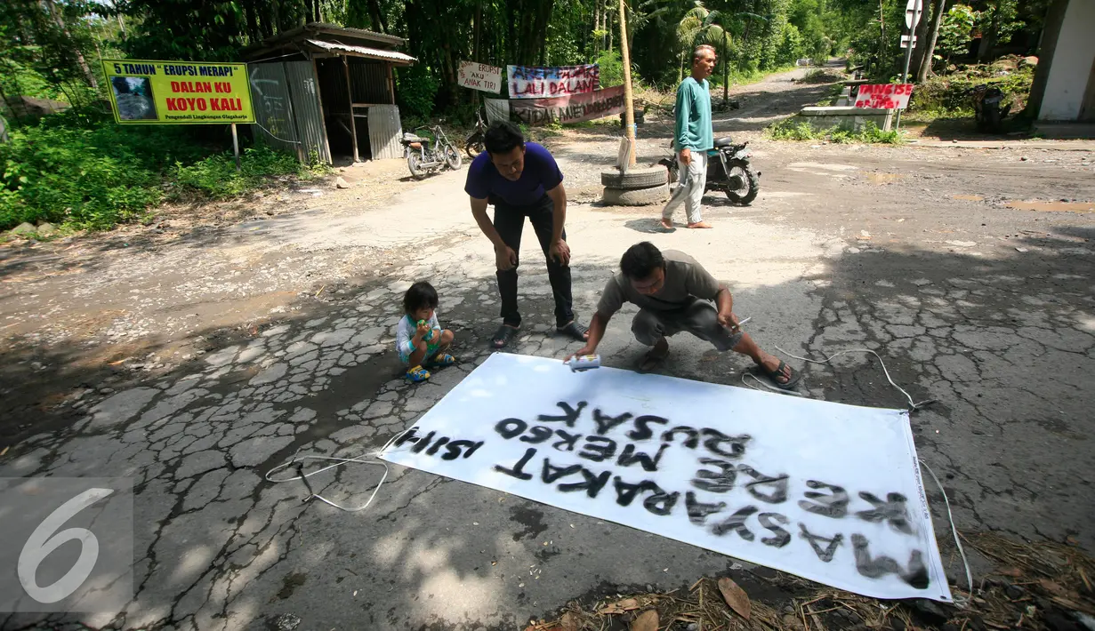 Warga memasang spaduk di jalan desa Glagahsari, Cangkringan Sleman yang di tanami sejumlah pohon, (23/2). Aksi penanaman pohon sebagai bentuk protes atas rusaknya jalan yang belum diperbaiki sejak 5 tahun letusan Merapi. (Liputan6.com/Boy Harjanto)