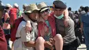 Petugas kepolisian dan penyelamat membantu turis asing yang dievakuasi dari Gili Trawangan saat tiba di Pelabuhan Bangsal, Lombok Utara, NTB, Selasa (7/8). Ribuan turis asing dievakuasi dari Gili Trawangan setelah gempa Lombok. (ADEK BERRY/AFP)