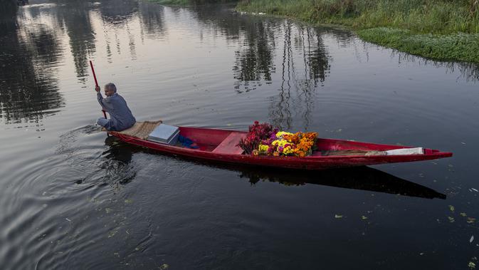 Seorang pedagang bunga Kashmir mendayung kapalnya melalui Danau Dal di Srinagar, Kashmir yang dikuasai India (18/10/2020). (AP Photo/Dar Yasin)