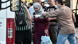 Seorang imigran wanita bersiap naik bus selama operasi polisi di pusat Athena, Yunani (19/9/2019). Pembersihan para imigran di pusat kota tersebut digerakkan oleh pemerintah konservatif yang baru. (AFP Photo/Louisa Gouliamaki)