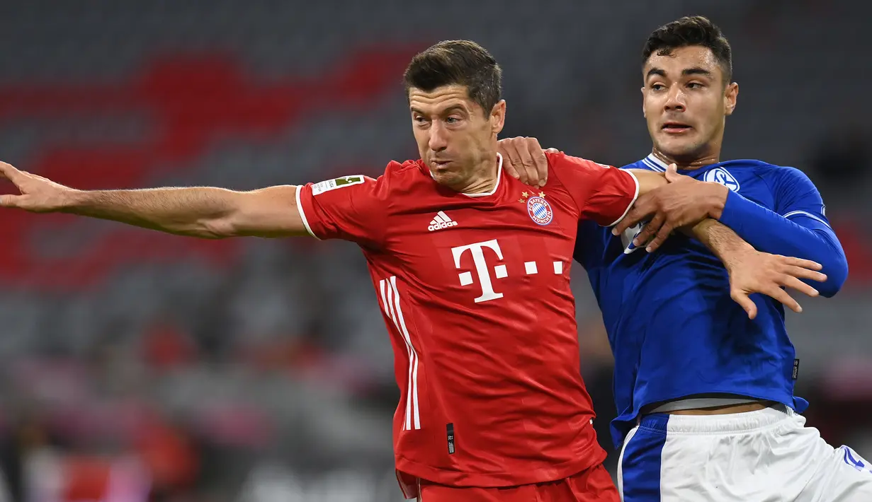 Penyerang Bayern Munchen, Robert Lewandowski, berebut bola dengan bek Schalke, Ozan Kabak, pada laga Liga Jerman di Allianz Arena, Sabtu (19/9/2020) dini hari WIB. Bayern Munchen menang 8-0 atas Schalke. (AFP/Christof Stache)