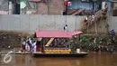 Sejumlah siswa SD usai menaiki perahu eretan untuk berangkat ke sekolah di Sungai Ciliwung, Jakarta, Senin, (4/1). Usai libur panjang para siswa kembali beraktivitas mengikuti tahun ajaran 2016-2017. (Liputan6.com/Gempur M Surya)