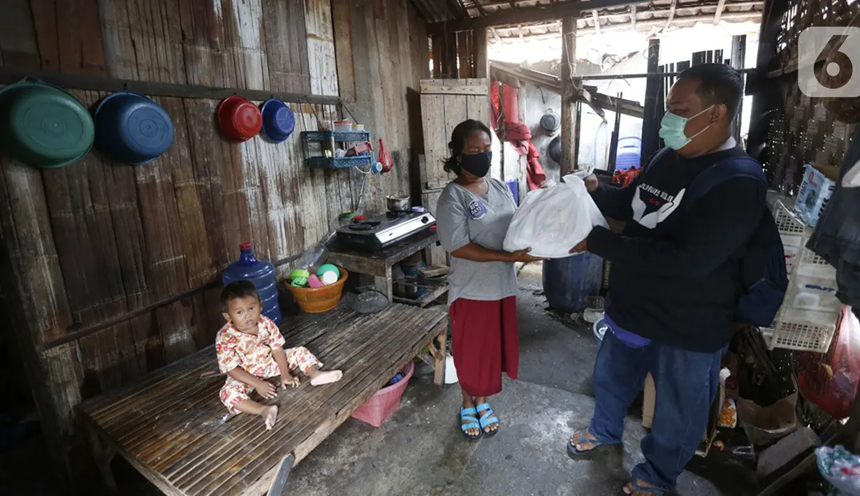 Jurnalis menyalurkan bantuan sembako di Pulau Panjang, Serang, Banten, Sabtu (30/1/2021). Bantuan sembako dan uang tunai bagi warga kurang mampu diberikan karena menurunnya daya beli masyarakat untuk mengonsumsi ikan turun akibat pandemi Covid-19. (Liputan6.com/Pool/JP)