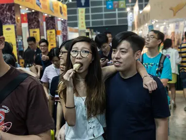 Sejumlah pengunjung menikmati makanan selama Food Expo di Hong Kong (19/8). Pameran makanan tahunan ini diadakan di Hong Kong Exhibition and Convention Center dan berlangsung dari 17-21 Agustus. (AFP Photo/Isaac Lawrence)