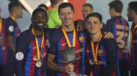 Para pemain Barcelona, Ousmane Dembele, Robert Lewandowski dan Gavi berpose dengan trofi usai menjuarai final Piala Super Spanyol di Stadion King Fahd, di Riyadh, Arab Saudi, Senin (16/1/2023). Trofi ini sekaligus menjadi trofi pertama Xavi Hernandez sebagai juru taktik Barcelona. (AP Photo/Hussein Malla)